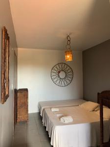 ein Schlafzimmer mit einem Bett und einer Uhr an der Wand in der Unterkunft Bed & Breakfast Casa de Valeria in Barra Nova + 64 Fotos