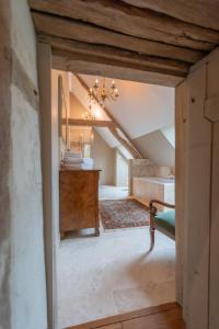 an attic room with a bed and a dresser in it at Domaine de Charnay Villégiature Sologne in Vierzon