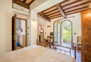 a bedroom with a bed and a large window at Glicine Apartment Podere Giardino in Montalcino