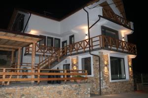 a house with a staircase on the side at night at Вила Дружинци in Druzhintsi