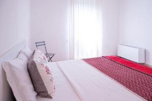 a bedroom with a white bed with pillows and a window at Ca' Popolo Venice in Mestre