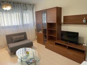 a living room with a television and a chair and a table at Apartamento Barbanza con plaza de garaje in Porto do Son