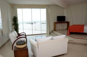 uma sala de estar com um sofá branco e uma cama em San Fernando Hotel em São Luís