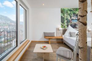 a living room with a white couch and large windows at Regina's Gästehaus in Weisenbach