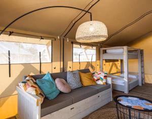 a living room with a couch and a bunk bed at Layla Glamping in Nir Dawid