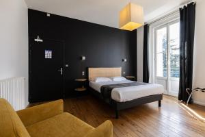 een slaapkamer met een bed, een stoel en een bank bij Hôtel Château La Chèze - Bordeaux Floirac in Floirac