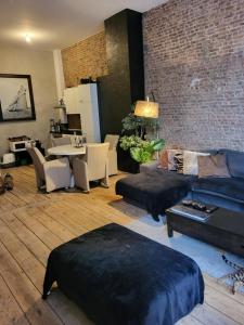 uma sala de estar com um sofá e uma parede de tijolos em Cosy em Antuérpia