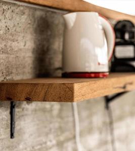 a coffee cup sitting on a wooden shelf at Layla Glamping in Nir Dawid