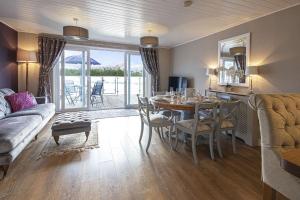 a living room with a table and a dining room at Spring Lake 19, The Lake House in South Cerney