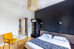 1 dormitorio con 1 cama grande y 1 silla amarilla en Hôtel Château La Chèze - Bordeaux Floirac, en Floirac