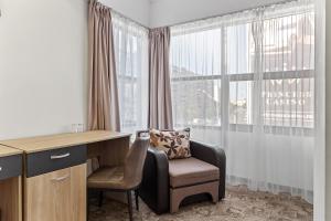 a office with a chair and a desk and a window at Lina Hotel in Bucharest