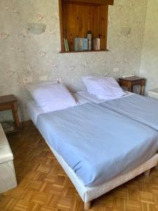 a large bed with two pillows on it in a bedroom at Dormez dans la chambre du meunier ! in Germolles-sur-Grosne