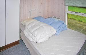 a bed in a small room with pillows on it at Cozy Home In Grenaa With Wifi in Stokkebro