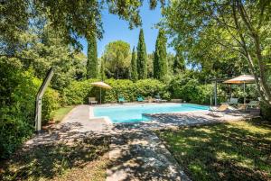 an image of a swimming pool in a yard with trees at Melograno Apartment Podere Giardino in Montalcino