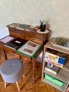 einen Holzschreibtisch mit einem Stuhl und einem Tisch mit Büchern in der Unterkunft Dormez dans la chambre du meunier ! in Germolles-sur-Grosne