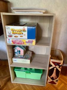 a book shelf filled with boxes and other toys at Dormez dans la chambre du meunier ! in Germolles-sur-Grosne
