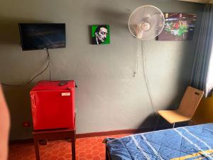 a bedroom with a red refrigerator and a fan at Riviera Beach in Pattaya
