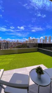 喬治市的住宿－2BR Georgetown Luxury Suite #RoofTopPool #Beacon，一个带桌椅的庭院和一个绿色草坪