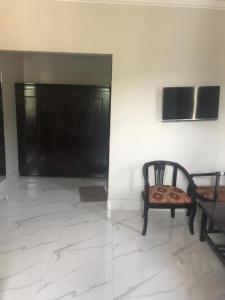 a room with a chair and a wall with black doors at Hotel La Orilla Muzaffarabad in Muzaffarabad