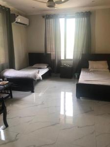 a bedroom with two beds and a large window at Hotel La Orilla Muzaffarabad in Muzaffarabad