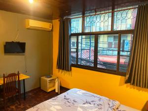 a bedroom with a window and a bed and a table at Riviera Beach in Pattaya