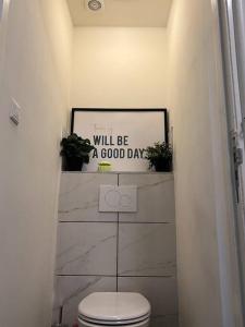 - une salle de bains avec toilettes et un panneau indiquant que vous passerez une bonne journée dans l'établissement Room 101 - Eindhoven, à Eindhoven