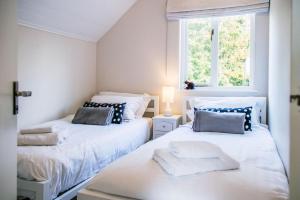 2 Betten in einem Zimmer mit 2 Fenstern in der Unterkunft Spring Lake 14, Lakeside Retreat in South Cerney