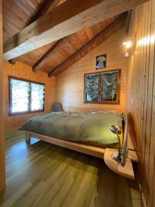 ein Schlafzimmer mit einem großen Bett in einem Holzzimmer in der Unterkunft La Grange à Coco avec jacuzzi in Bourg-Saint-Pierre