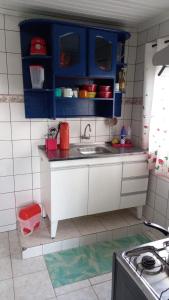 una pequeña cocina con armarios azules y fregadero en Big Hostel Brasil, en Manaus