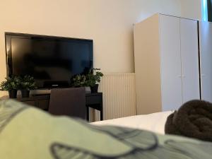 een slaapkamer met een flatscreen-tv en een bed bij Room 101 - Eindhoven in Eindhoven