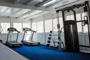 un gimnasio con tres máquinas de correr en una habitación en Hotel Las Gaviotas, en La Manga del Mar Menor