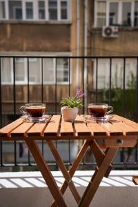 une table en bois avec deux tasses et une plante dessus dans l'établissement Merkuri Apart, à Istanbul