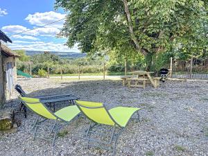 un tavolo da picnic con 2 sedie, un tavolo da picnic e una panca da picnic di Maison de vacances au cœur de la nature a Sully