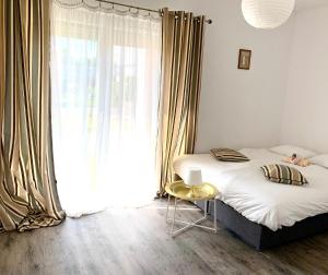 ein Schlafzimmer mit einem Bett und einem großen Fenster in der Unterkunft Sunset Apartments Kropla Baltyku in Darłówko