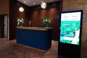 a lobby with a reception counter with a screen at NAS Hotel in Al Khobar