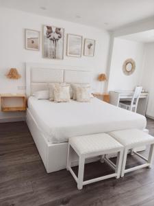duże białe łóżko z ławką w sypialni w obiekcie SUPERTUBOS HOUSE Peniche w mieście Peniche