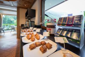 une boulangerie avec une variété de pâtisseries à l'exposition dans l'établissement Hotel Foresta, à Moena