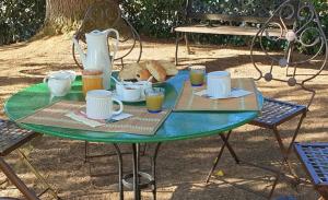uma mesa verde com bebidas e pão em L'AUGLANAS em Tauriac-de-Naucelle
