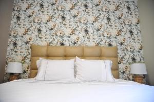 a bed with white pillows and a floral headboard at Apartman Ljubica in Vrnjačka Banja