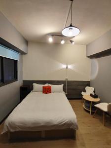 a bedroom with a bed with a red pillow on it at 駐典Txg in Taichung