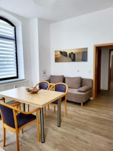 een woonkamer met een tafel en stoelen en een bank bij Ferienwohnung WESTEND in Plauen