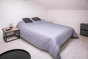 a bedroom with a bed and a table with a night stand at Le Beauvoir in Saint-Marcellin