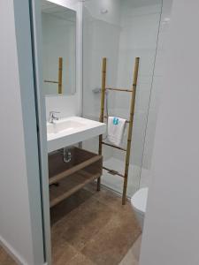 ein Badezimmer mit einem Waschbecken, einem WC und einem Spiegel in der Unterkunft Bamblue Boutique Apartments in Pineda de Mar