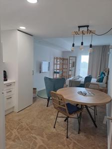 eine Küche und ein Wohnzimmer mit einem Tisch und Stühlen in der Unterkunft Bamblue Boutique Apartments in Pineda de Mar