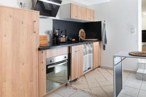 uma cozinha com armários de madeira e um fogão em Le Beauvoir em Saint-Marcellin