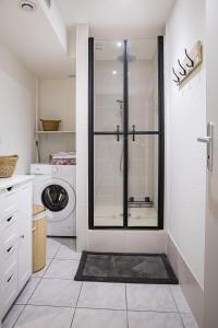 uma casa de banho com um chuveiro e uma máquina de lavar roupa em Le Beauvoir em Saint-Marcellin
