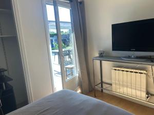 Schlafzimmer mit einem Bett, einem TV und einem Fenster in der Unterkunft la petite bulle in Montagnat