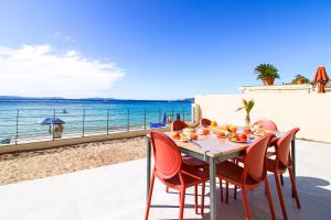 - une table à manger avec des chaises et une vue sur la plage dans l'établissement SELECT' - Appartement sur la plage de Cavalière - Vue mer - 4 étoiles - BLUEMOON, au Lavandou