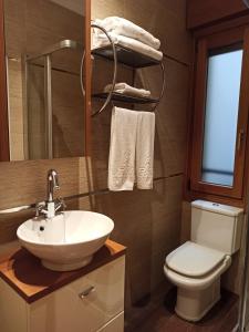 ein Badezimmer mit einem weißen Waschbecken und einem WC in der Unterkunft Apartamentos ARVA París in León
