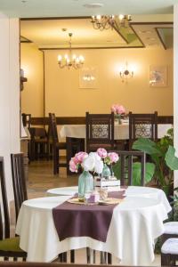 un comedor con una mesa con flores. en Meteor Family Hotel, en Chepelare